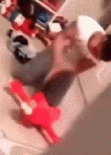 A Blurry Picture Of A Person Sitting On A Couch With A Stuffed Animal . GIF