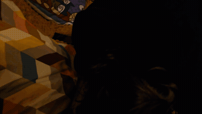 A Blurry Picture Of A Person Sitting On A Couch With Their Legs Crossed GIF