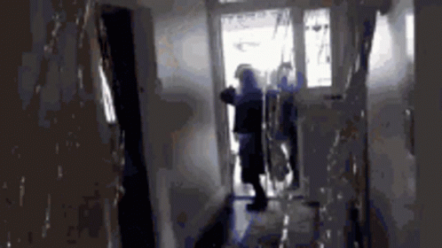 A Blurry Picture Of A Person Standing In A Hallway GIF