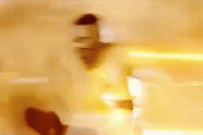 A Blurry Picture Of A Person Standing In A Room With A Yellow Background GIF