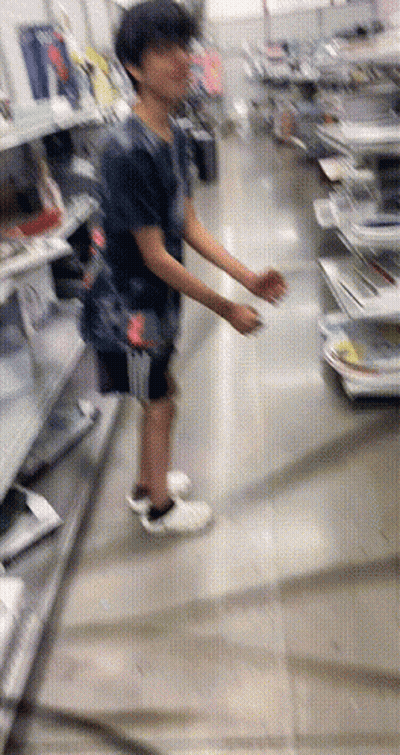 A Blurry Picture Of A Person Standing In A Store Looking At Something GIF