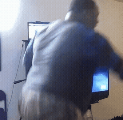 A Blurry Picture Of A Person Standing In Front Of A Computer Monitor GIF