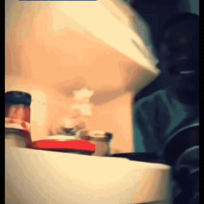 A Blurry Picture Of A Person Standing In Front Of A Refrigerator GIF