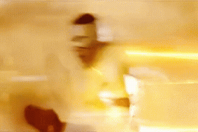 A Blurry Picture Of A Person Standing In Front Of A Wall With A Light Coming Out Of It . GIF