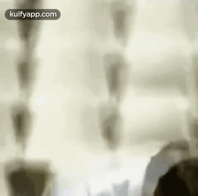 A Blurry Picture Of A Person Standing In Front Of A Window With A White Curtain . GIF