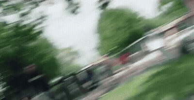 A Blurry Picture Of A Person Walking Down A Sidewalk . GIF
