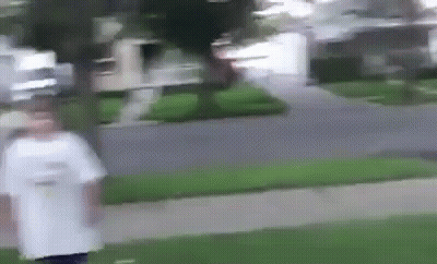 A Blurry Picture Of A Person Walking Down A Sidewalk In Front Of A House . GIF