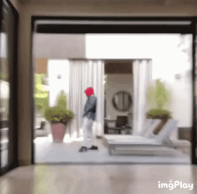 A Blurry Picture Of A Person Walking Through A Sliding Glass Door GIF