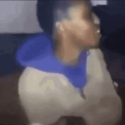 A Blurry Picture Of A Person Wearing A Blue Hoodie And A White Shirt . GIF