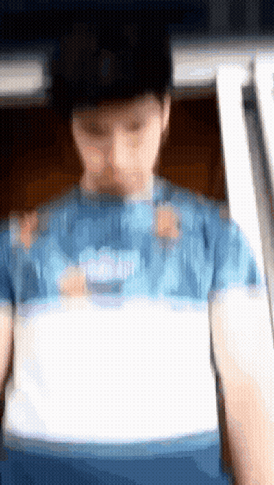 A Blurry Picture Of A Person Wearing A Blue Shirt GIF