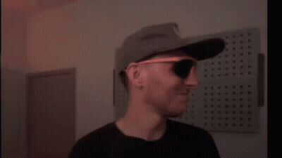 A Blurry Picture Of A Person Wearing A Hat And Sunglasses . GIF