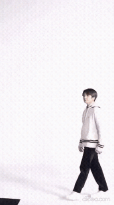 A Blurry Picture Of A Person Wearing A White Jacket And Holding A Purse . GIF