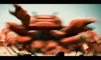 A Blurry Picture Of A Red Crab Crawling On The Ground GIF