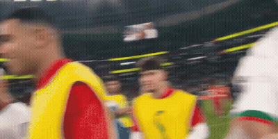 A Blurry Picture Of A Soccer Game With Players In Yellow Vests GIF