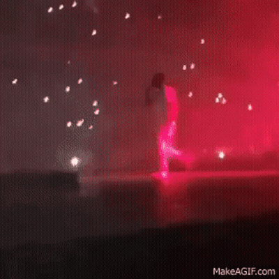 A Blurry Picture Of A Stage With Red Lights Coming Out Of The Ceiling GIF