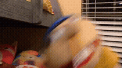 A Blurry Picture Of A Stuffed Animal Being Thrown Into A Container GIF