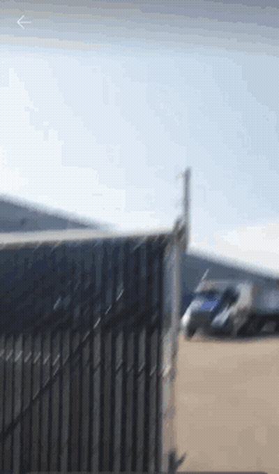 A Blurry Picture Of A Truck Parked Behind A Gate GIF