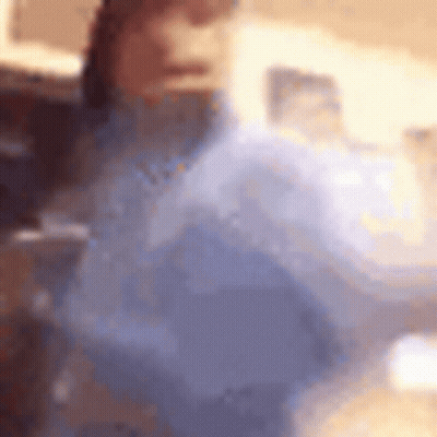 A Blurry Picture Of A Woman In A Blue Dress Holding A Balloon . GIF