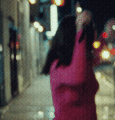 A Blurry Picture Of A Woman In A Pink Sweater GIF