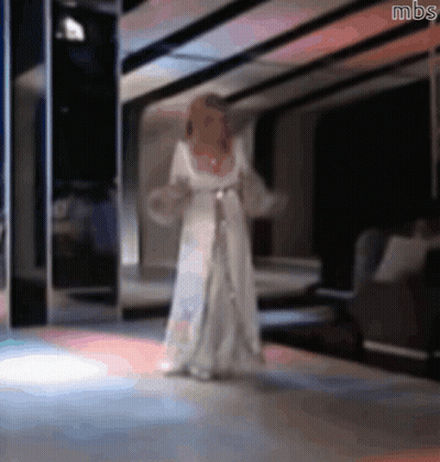 A Blurry Picture Of A Woman In A White Dress With Mbs Written On The Bottom GIF