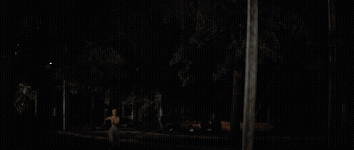 A Blurry Picture Of A Woman 'S Back In The Dark GIF
