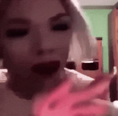 A Blurry Picture Of A Woman 'S Face With A Pink Flame Coming Out Of Her Mouth GIF