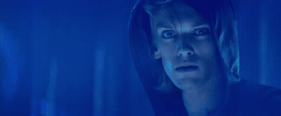 A Blurry Picture Of A Woman 'S Face With Blue Lights In The Background GIF