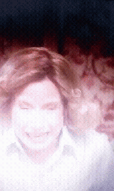 A Blurry Picture Of A Woman With Her Eyes Closed And Her Hair Blowing In The Wind GIF