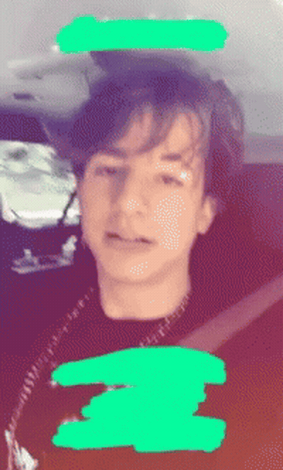 A Blurry Picture Of A Young Boy With A Green Circle Around His Head GIF