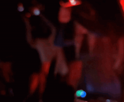 A Blurry Picture Of People Dancing In A Dark Room With A Sign On The Wall That Says ' I Love You ' GIF