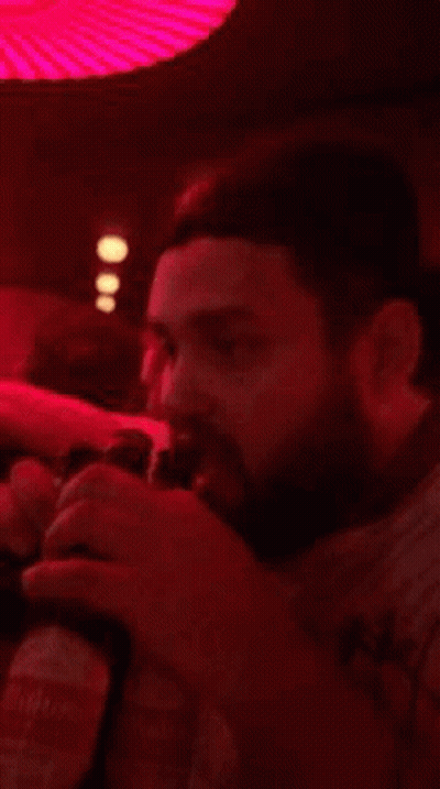 A Blurry Picture Of People Dancing In A Dark Room With Red Lights GIF