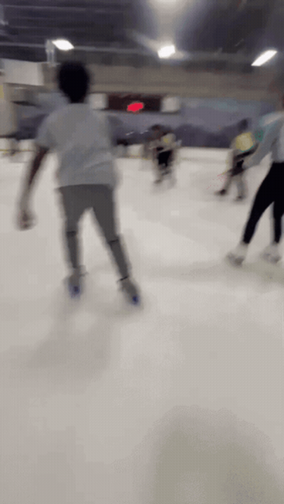 A Blurry Picture Of People Ice Skating In A Rink GIF