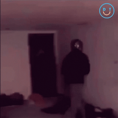 A Blurry Picture Of People In A Dark Room With A Smiley Face In The Corner GIF