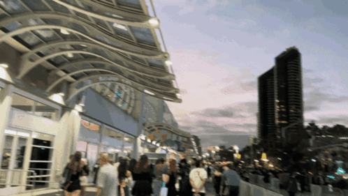 A Blurry Picture Of People Walking In Front Of A Building With A Sign That Says ' Sd Convention Center ' On It GIF