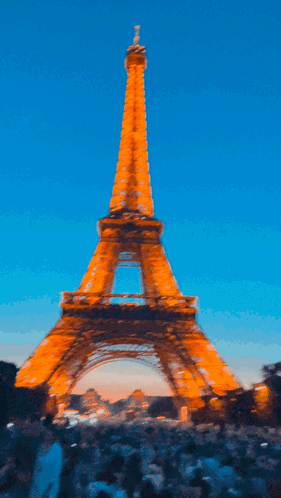 A Blurry Picture Of The Eiffel Tower At Sunset GIF