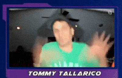 A Blurry Picture Of Tommy Tallarico With His Hands Outstretched GIF