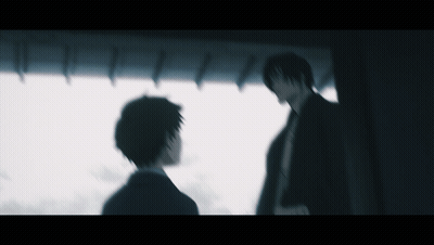 A Blurry Picture Of Two Men Standing In A Dark Room GIF