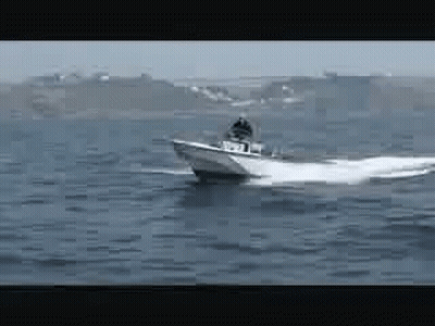 A Boat Is Floating On Top Of A Large Body Of Water GIF