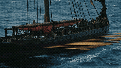 A Boat With A Red Sail Is Floating On The Water GIF