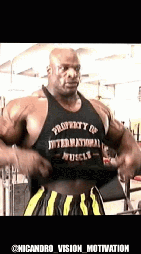 A Bodybuilder Is Taking Off His Shirt In A Gym . GIF