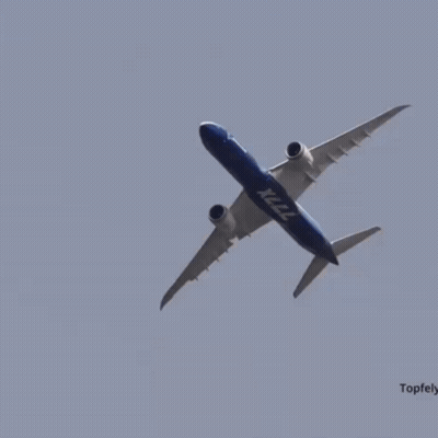 A Boeing X222 Plane Is Flying Through A Clear Blue Sky GIF