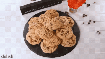A Book Called Magnolia Table Sits On A Table Next To A Plate Of Cookies GIF