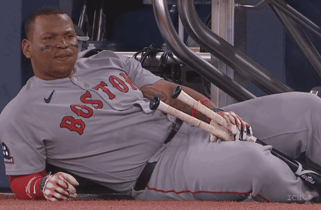 A Boston Baseball Player Laying On The Ground With His Bats GIF