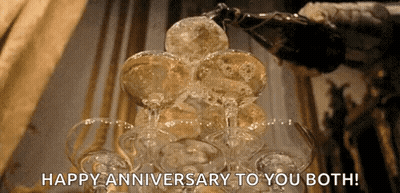 A Bottle Of Champagne Is Poured Into A Stack Of Champagne Glasses With The Words Happy Anniversary To You Both GIF