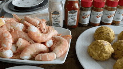A Bottle Of Cocktail Sauce Sits On A Table Next To A Pile Of Shrimp GIF