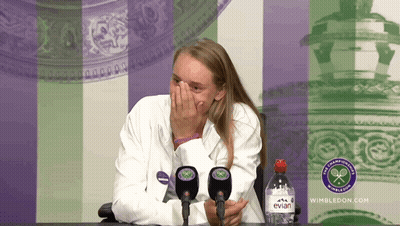 A Bottle Of Evian Water Sits In Front Of A Woman Covering Her Face GIF