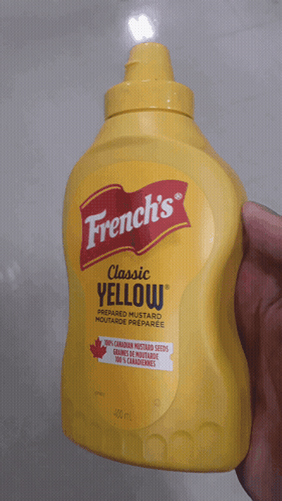 A Bottle Of French 'S Classic Yellow Mustard In A Hand GIF