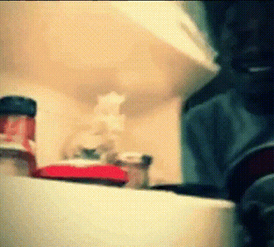 A Bottle Of Ketchup Sits On A Shelf In A Kitchen .. GIF