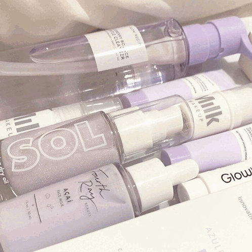 A Bottle Of Milk Makeup Sits Next To A Bottle Of Sol And A Bottle Of Glow GIF