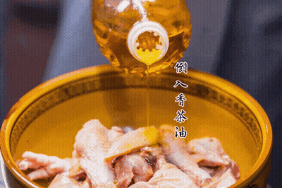 A Bottle Of Oil Is Being Poured Into A Bowl Of Meat GIF